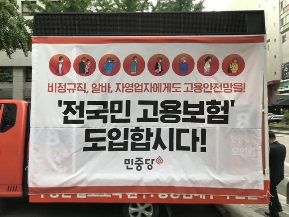 민중당 당사(서울시 여의도 소재) 앞에 현수막이 걸린 차량이 주차된 모습. 이 현수막은 '전 국민 고용보험' 도입을 홍보하는 내용이 담겨있다. 정부는 보험설계사를 포함한 특수고용직 노동자 9개 직종부터 고용보험 가입을 추진하겠다고 밝혔다. = 김청민 기자