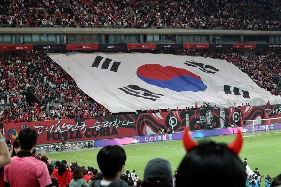 지난 9월27일 서울 마포구 서울월드컵경기장에서 열린 한국 대 카메룬 축구 대표팀의 평가전에서 붉은 악마가 대형 태극기를 펼치고 있다. ⓒ 연합뉴스