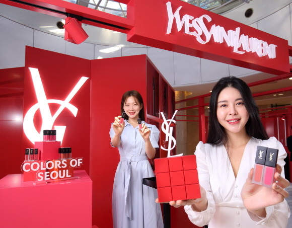 지난 19일 서울 중구 소공동에 위치한 롯데백화점 본점 지하 1층 입생로랑 팝업스토어에서 모델들이 신제품을 들고 홍보하는 모습. © 롯데백화점