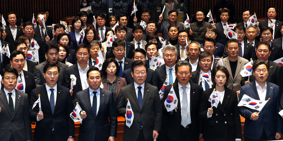 더불어민주당이 16일 국회 예결위회의장에서 열린 의원총회에 태극기를 내세운 대정부 투쟁을 전개했다. ⓒ 연합뉴스
