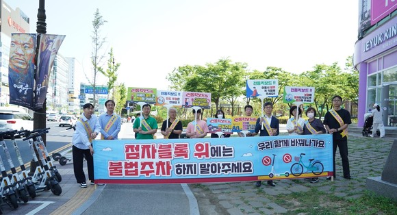 천안시가 지난 25일 충남사회혁신센터와 시민들이 함께하는 킥보드 점자블록 방치 금지 스티커 부착 캠페인 진행 후기념촬영을 하고 있다. ⓒ 천안시