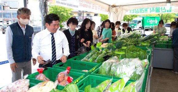 김창규 제천 시장이 지난 26일 이마트제천점 앞 행사장에서 직거래 장터 현장을 방문해 채소와 과일 등을 살펴보고 있다. ⓒ 제천시