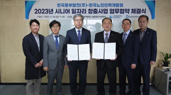 26일 중부발전 김호빈 사장(왼쪽 네번째)과 김미곤 한국노인인력개발원장(왼쪽 세번째) 등 참석자들이 협약서를 들고 기념촬영을 하고 있다. ⓒ 중부발전