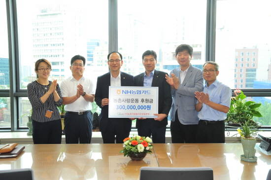정성환 NH농협카드 부장(왼쪽 세 번째)과 정재길 농촌사랑범국민운동본부장(네 번째)이 관계자들과 기념촬영을 하고 있다. ⓒ NH농협카드