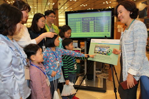 종로구 SC은행 본점에서 '수퍼히어로의 하루' 행사에 참여한 SC은행 임직원과 자녀들이 박현주 SC은행 전무(오른쪽)로부터 영업점의 객장 업무에 대해 설명을 듣고 있다. ⓒ SC은행