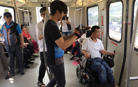 용인시의 경전철에서 중증장애인 주연 배우와 촬영팀 직원들이 영화를 찍고 있어요. ⓒ 용인시