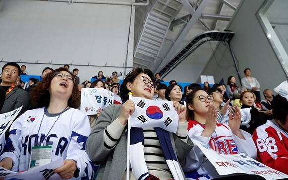 대통령 부인인 김정숙 여사가 태극기를 들고 아이스하키 경기를 보고 있어요. ⓒ 청와대
