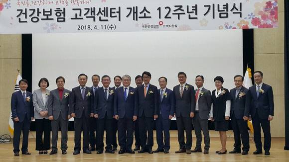 김용익 건보공단 이사장과 12개 협력사 대표가 건강보험 고객센터 개소 12주년을 자축했다. ⓒ 국민건강보험공단