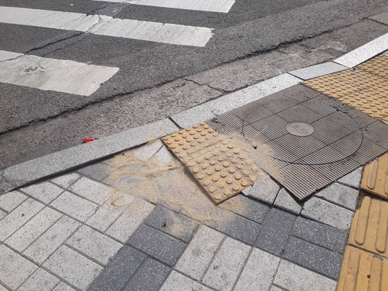 시각장애인에게 횡단보도임을 알려주는 정지 보도불록 사이에 맨홀이 있고, 블록시공도 제대로 되지 않은 모습. = 장귀용 기자