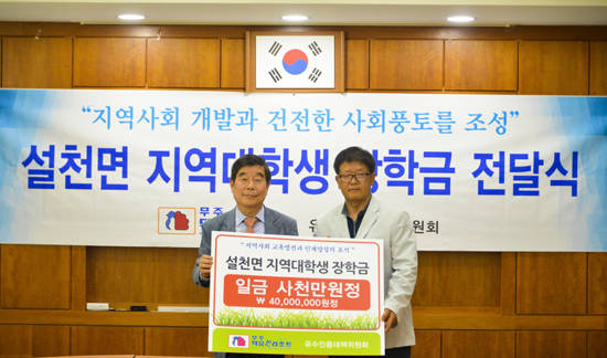 5월31일 오후 김시권 무주덕유산리조트 대표이사(왼쪽)가 설천면 주민자치센터에서 백남운 유수인용대책위원회 위원장에게 저소득가구 대학생 장학금을 전달하는 모습. ⓒ 부영