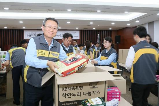 '착한누리 나눔박스'를 포장하고 있는 신홍섭 KB저축은행 대표. ⓒ KB저축은행