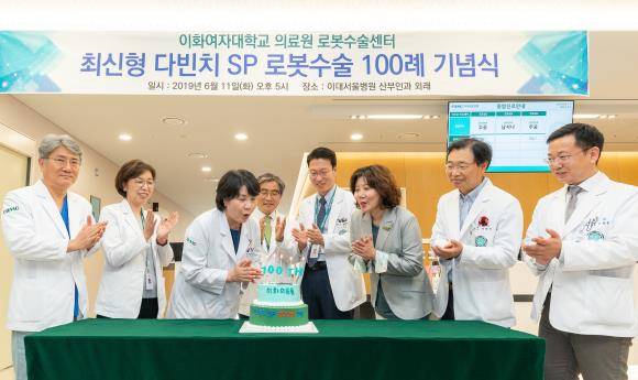 지난 11일 이대서울병원 2층 산부인과 외래에서 진행된 다빈치 SP 로봇수술 100례 달성 기념식에서 참석자들이 기념 케이크 촛불을 끄고 있다. ⓒ 이화의료원