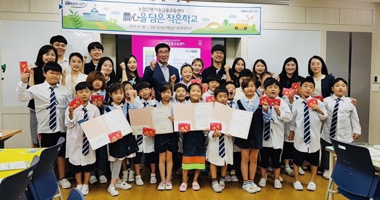 지난 8일 경북 칠곡군 왜관읍 낙산초등학교에서 최정훈 농협은행 개인고객부장(맨 뒷줄 가운데)과 대학생 봉사단 'N돌핀 7기'들이 기념촬영을 하고 있다. ⓒ NH농협은행