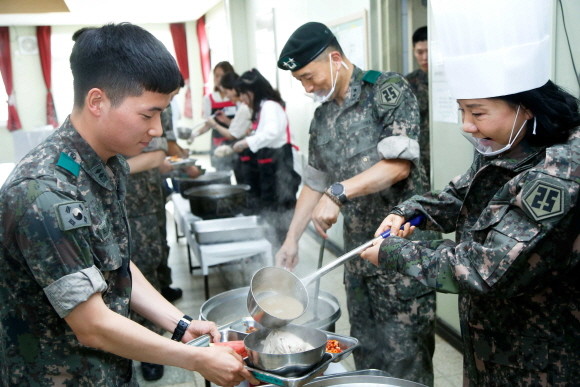 25보병사단을 방문한 최연매 김정문알로에 회장(오른쪽)이 군장병들에게 점심으로 삼계탕 특별식을 제공하고 있다. ⓒ 김정문알로에