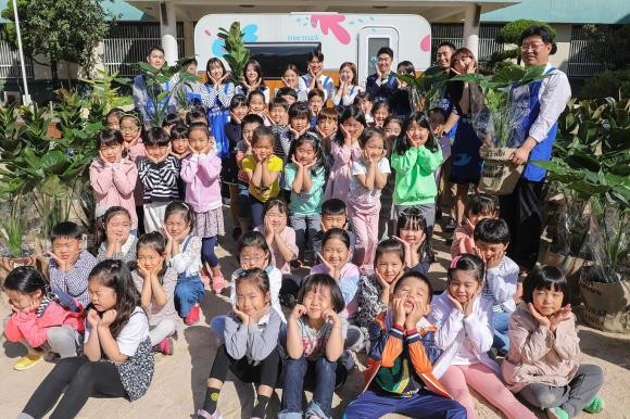 23일 오전 서울 금천구 가산초등학교에서 현대백화점 직원과 가산초등학교 학생들이 전달할 공기정화식물과 함께 기념촬영을 하고 있다. ⓒ 현대백화점