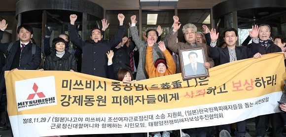 일제 강제징용 피해자 및 가족들이 미쓰비시중공업을 상대로 낸 손해배상청구 청구소송 상고심에서 승소했다. 대법원 앞에서 만세를 펼치는 모습. ⓒ 연합뉴스