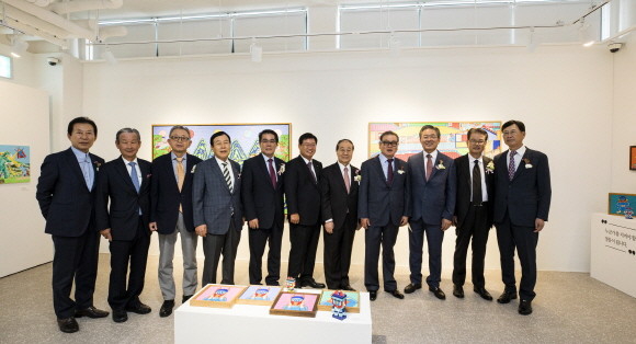 반도문화재단 '아이비 라운지' 개관식에서 권홍사 재단 이사장(사진 오른쪽 네 번째) 및 참석인사들이 '태권브이(V)' 작가로 유명한 성태진 작가의 작품이 전시된 갤러리에서 기념촬영을 하고 있다. ⓒ 반도건설