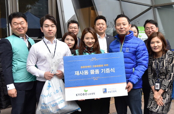 지난 15일 오후 광화문 교보생명 본사에서 열린 '함께하는 나눔 캠페인' 자선 바자회에서 교보생명 임직원들과 윤성우 밀알복지재단 나눔사업부장(오른쪽 두 번째)이 재사용 물품 기증식 기념사진을 촬영하고 있다. ⓒ 교보생명