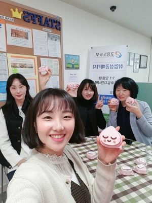 스탭스 직원들이 이벤트를 통해 선물받은 떡으로 인증샷을 찍고 있다. ⓒ 스탭스