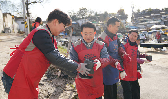 하석주 롯데건설 대표이사(왼쪽에서 두 번째)가 샤롯데 봉사단원들과 함께 연탄을 나르고 있다. ⓒ 롯데건설