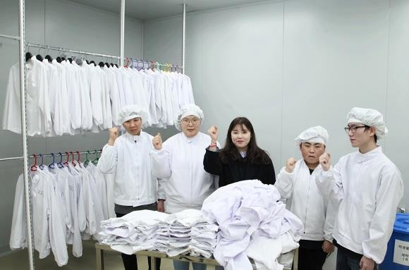 JW중외제약과 JW생명과학이 공동출자로 설립한 제약업계 최초 자회사형 장애인표준사업장 생명누리가 새해부터 본격적인 업무에 돌입했다. 민수정 사회복지사(가운데)와 장애인근로자들이 JW당진생산단지 작업장에서 기념촬영을 하고 있다. ⓒ JW홀딩스