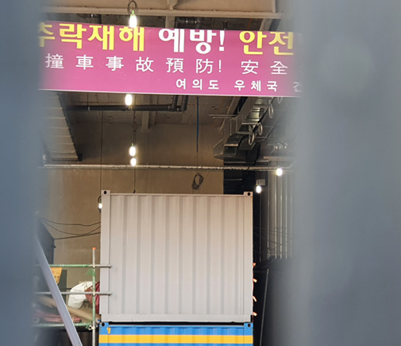 건설현장 철문 너머로 보이는 안전당부 플랜카드. 한국어 밑에 중국어 문구가 중국인들이 다수 유입된 건설현장의 현실을 여실히 보여준다. = 장귀용 기자