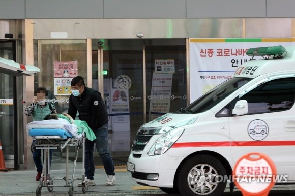 지난 24일 정부가 감염병전담병원으로 지정한 광주 남구 빛고을전남대병원에서 사설 구급요원이 입원 환자를 다른 병원으로 옮기고 있는 모습. ⓒ 연합뉴스