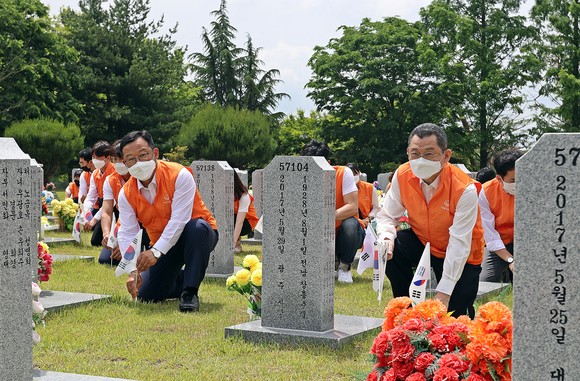 한화그룹 임직원들이 태극기 교체 봉사활동을 하는 모습. ⓒ 한화