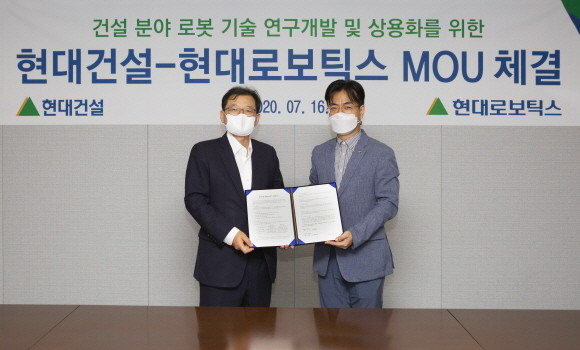 현대건설·현대로보틱스 MOU 체결식에서 박구용 현대건설 기술연구소장과 윤대규 현대로보틱스 로봇연구소장이 기념 촬영을 하고 있다. ⓒ 현대건설