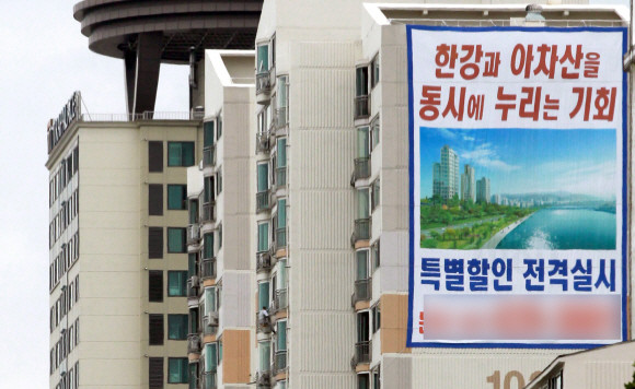 10년 전 이맘때는 부동산 경기 침체로 중소 건설사들의 부도와 분양연기가 속출했다. 2010년 7월 부동산 경기를 대변하듯 서울의 한 도로 옆 아파트에 서울시내 미분양 아파트를 특별할인 한다는 현수막이 걸려 있다. ⓒ 연합뉴스