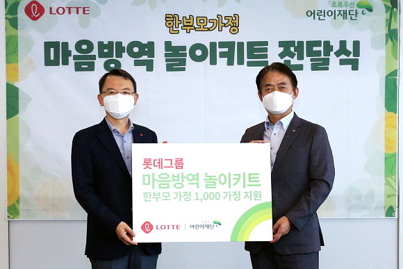 롯데는 11일 롯데월드타워에서 한부모가정 1000가구에 지원할 '마음방역 놀이키트'를 초록우산 어린이재단에 전달했다. 사진은 오성엽 롯데지주 커뮤니케이션실 사장(왼쪽), 홍장표 초록우산 어린이재단 부회장이 전달 기념 촬영 모습. © 롯데지주