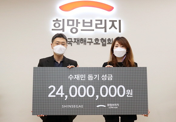 윤형원 신세계백화점 영업전략팀 팀장(왼쪽)과 정서윤 희망브리지 구호모금본부장이 성금 전달식 후 기념 촬영을 하고 있다. © 신세계백화점