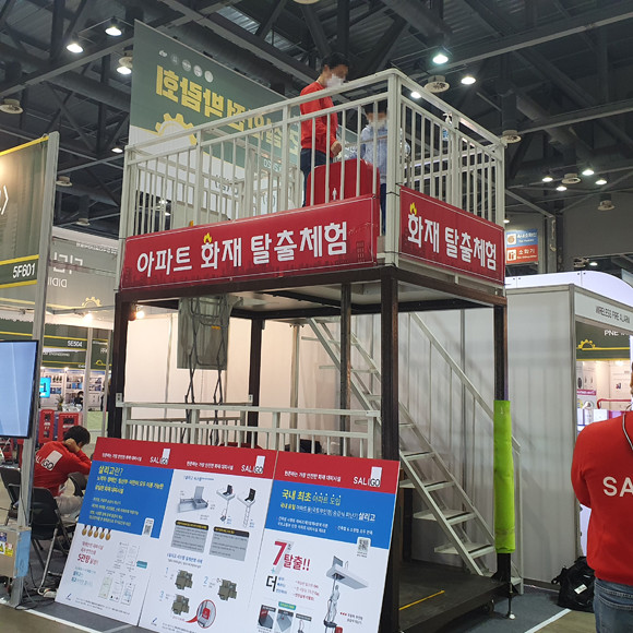 한국건설안전박람회에 선보인 제품 중에는 다양한 체험을 할 수 있는 제품들도 마련돼 방문객들이 직접 체험을 해보기도 했다. 사진은 부모와 함께 박람회를 방문한 미취학아동이 행사장 안에 마련된 승강식피난기를 체험해보는 모습. = 장귀용 기자