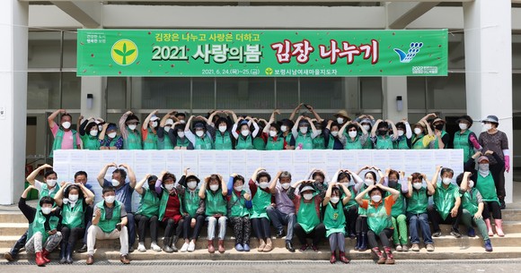 새마을운동 보령시지회는 지난 25일 어려운 이웃에게 전달할 사랑의 김치 나누기 행사를 개최 후 기념촬영을 하고 있다. ⓒ 보령시
