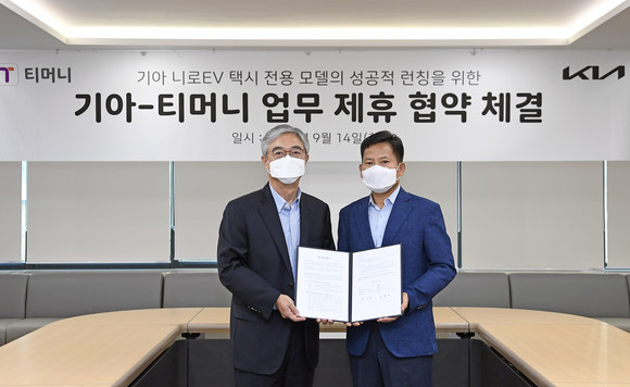 서울역 서울시티타워에 위치한 티머니 사옥에서 김상대 기아 기업전략실장(오른쪽)과 김태극 티머니 대표이사(왼쪽)이 업무 제휴협약 체결 후 기념사진을 촬영하는 모습. ⓒ 기아