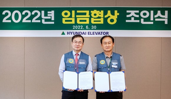 현대엘리베이터 노사가 협상 개시 보름만에 2022년 임금협상을 조기 타결했다. 노사는 원자재 가격 폭등, 건설경기 침체, 코로나19 등 경영위기에 공동으로 대응하고자 '위기극복을 위한 노사 공동 결의문'도 채택했다. 사진은 왼쪽부터 조재천 현대엘리베이터 대표이사, 손만철 노동조합위원장. ⓒ 현대엘리베이터