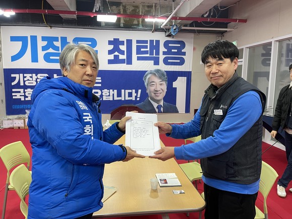 더불어민주당 최택용 후보가 밀레베어 직원들이 직접 손으로 쓴 수백잠에 도움 요청 편지를 전달받고 있다. ⓒ 최택용 후보 캠프