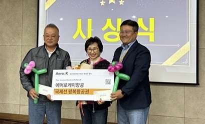 에어로케이항공 채정훈 영업운송본부장이 우수자원봉사자로 선정된 2인에게 항공권을 전달 후 기념촬영을 하고 있다. ⓒ 에어로케이항공