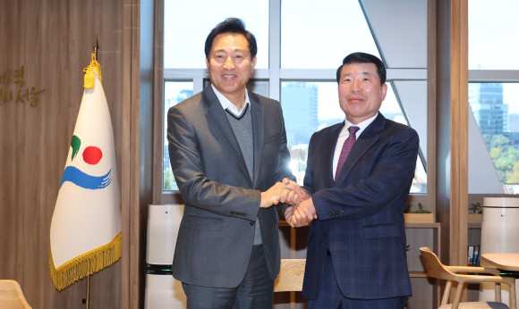 오세훈 서울시장과 백경현 구리시장이 13일 구리시의 서울시 편입 문제 등에 대해 논의하기 앞서 악수하고 있다. © 연합뉴스