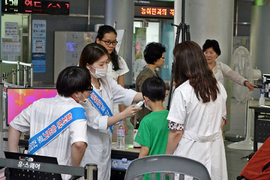 보건소 직원이 터미널에 설치된 열 화상감지기를 통과한 어린이의 체온을 확인하고 있다. ⓒ유·스퀘어