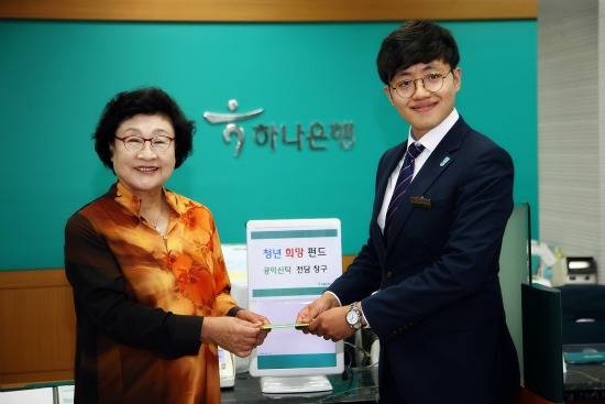 김필식 동신대학교 총장이 5일 하나은행 금남로지점을 방문해 청년 일자리 창출을 위한 청년희망펀드에 사재를 기부했다. 김 총장이 창구직원인 하나은행 신입사원에게 공익신탁증서를 전달하고 있다. ⓒ 동신대학교