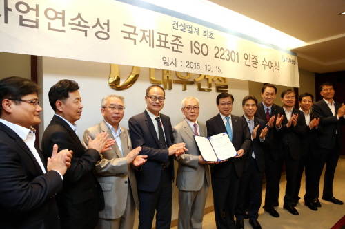 지홍근 대우건설 HSE-Q 실장과 BSI 코리아 천정기 회장이 ISO 22301 인증패를 들고 관계자들과 함께 기념촬영을 하고 있다. ⓒ 대우건설