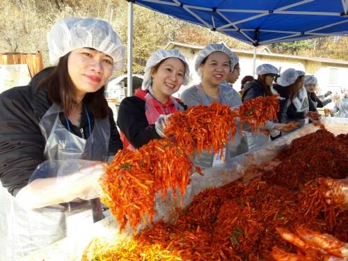 김장담그기 체험행사에 참여한 다문화 가족 여성들이 배추속을 들어보이며 환하게 웃고 있다. ⓒ 광주시