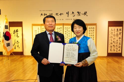 시에 자신의 서예작품 4점을 기증한다는 증서를 백경현 시장(왼쪽)에게 전달하고 있는 홍재인 작가. ⓒ 구리시