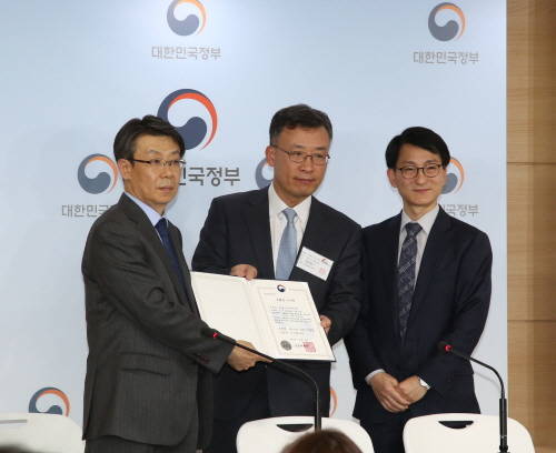 최훈 금융서비스국장이 심성훈 케이뱅크 초대 은행장(가운데)에게 은행업 본인가 인증서를 수여하고 있다. ⓒ 금융위