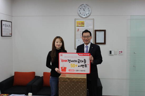 BNK부산은행 명형국 중부영업본부장이 3월20일 오전 부산은행 거제동 지점에서 '전세자금대출 50 플러스 이벤트' 첫 당첨 고객에게 경품을 전달했다. ⓒ BNK부산은행