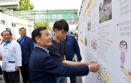 윤장현 광주광역시장이 지난 5월21일 동구 금남로에서 제52회 광주시민의 날 기념으로 열린 '광주시민총회'에 참석해 광주시민들이 제안한 100대 정책들을 모아 놓은 정책터널에서 청소년과 함께 투표를 하고 있다. ⓒ 광주광역시청