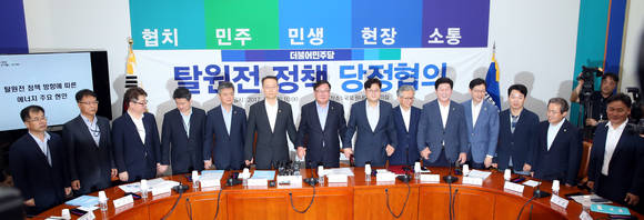 김태년 민주당 정책위의장과 백운규 산업통상자원부 장관 등이 31일 오전 서울 여의도 국회 당 원내대표회의실에서 열린 탈원전 정책 당정협의에서 손을 맞잡고 있다. ⓒ 뉴스1