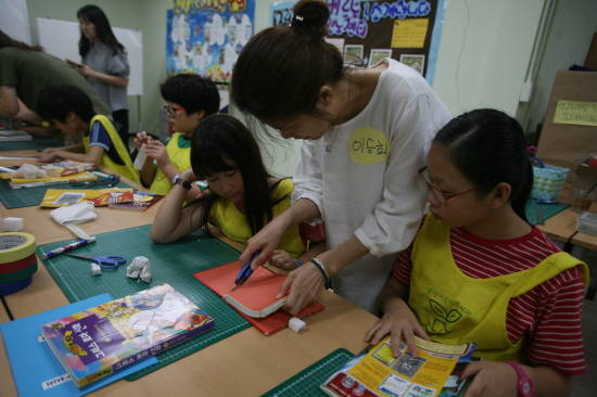 파손도서 보수를 지도하는 자원활동가 모습. ⓒ 용인시