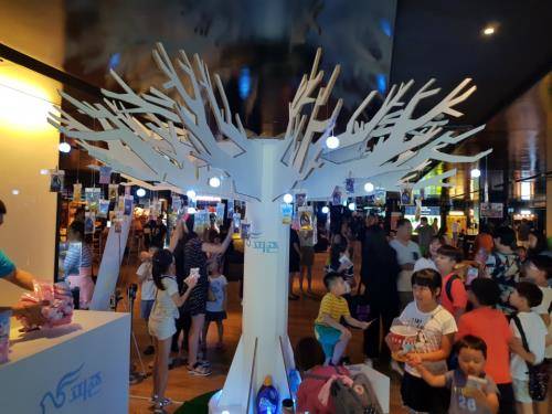 로비 중앙에 설치된 피죤 향기 나무 주변에 극장을 찾은 관객들 모습. ⓒ 피죤